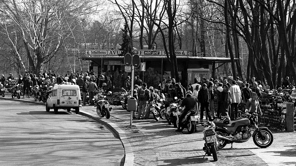 Schwarz-Weiß-Aufnahme des Motorradtreffs vor dem AVUS-Kiosk zu Mauerzeiten