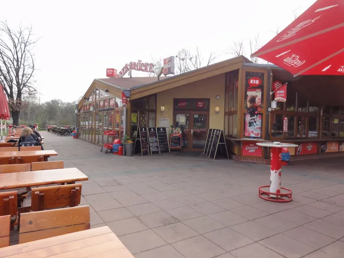 Holztische und Bänke auf der Terrasse vor dem Gasthaus Spinner-Brücke